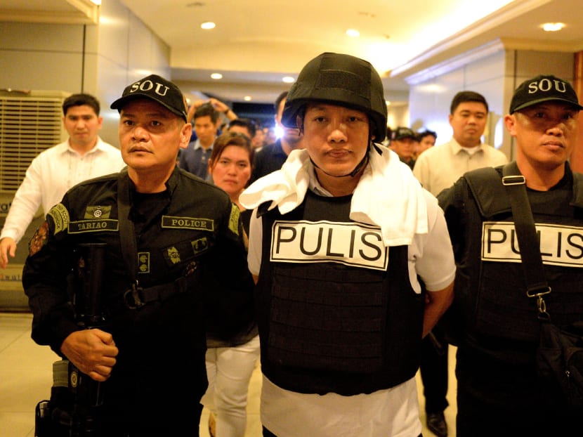 Police officer Ricky Sta. Isabel (C), one of the suspects in the kidnapping and murder of South Korean businessman Jee Ick Joo, is escorted by fellow policemen as they leave the National Bureau of Investigation (NBI) building in Manila on Jan 20, 2016. Photo: AFP