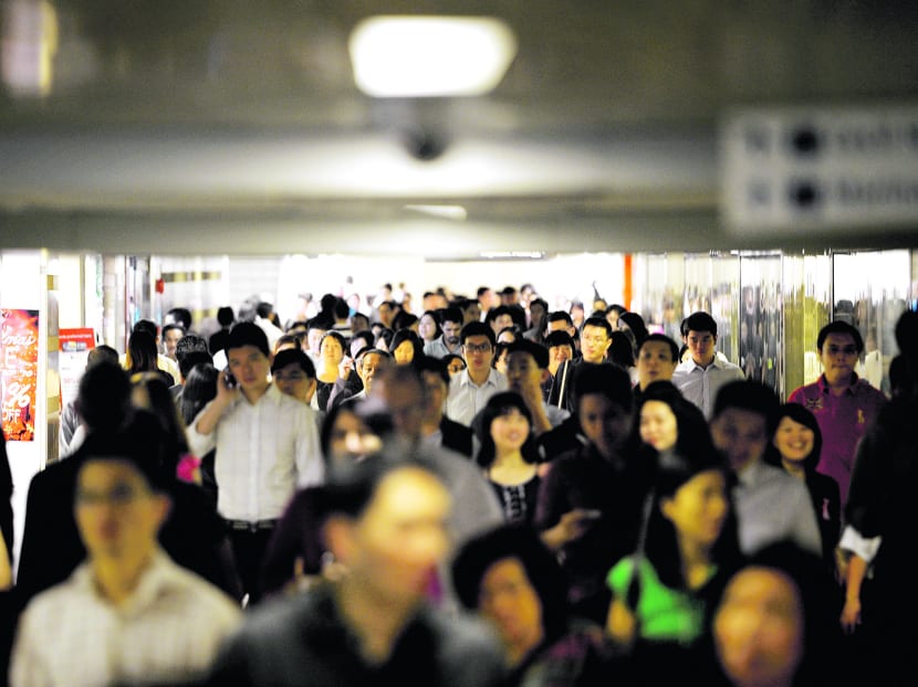 Office workers walk underground during lunch time in Singapore's central business district. Bloomberg file photo