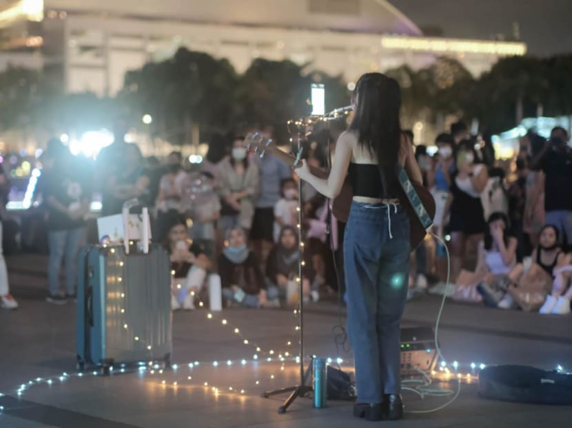 Busker Delvina See performing to a street crowd in Singapore.
