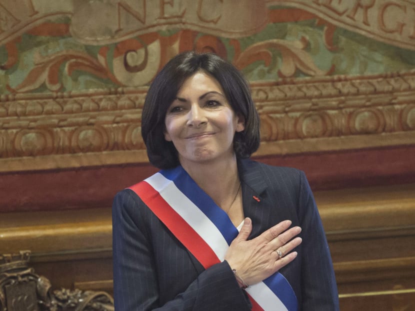 The new mayor of Paris Anne Hidalgo, wearing the mayoral sash in the colour of the French Republic, acknowledges applause after her election. Photo: AP