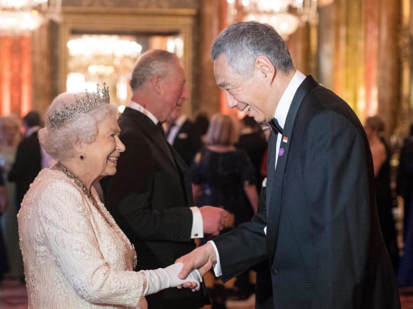 Queen Elizabeth II and Prime Minister Lee Hsien Loong in 2018 during the Commonwealth Heads of Government Meeting in London, England. Her oldest son Charles, now King Charles III, is standing in the background.