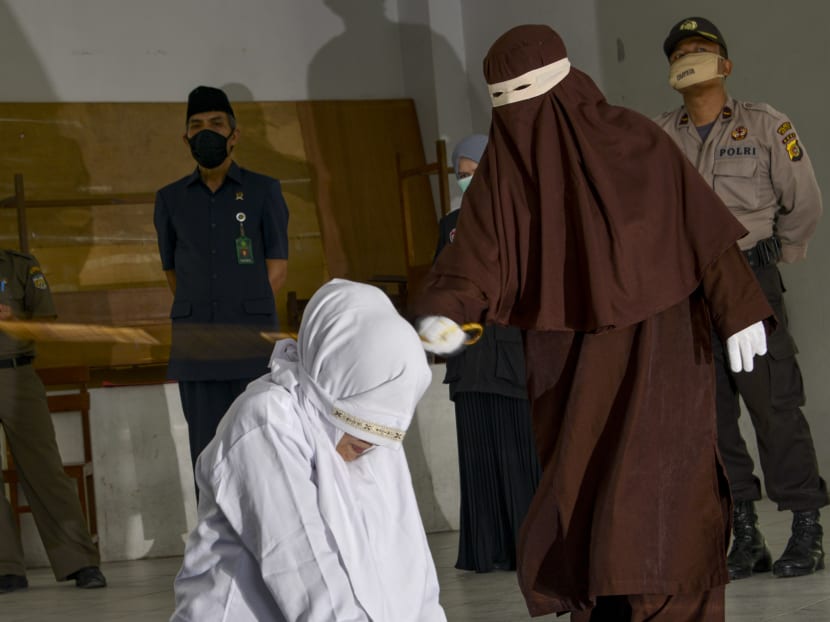 A woman is whipped by the religious police in a public building in Banda Aceh on April 21, 2020, as punishment after he was caught in close proximity with a man who is not her husband in a hotel.