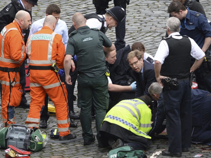 Conservative MP Tobias Ellwood (centre) helps emergency services attend to a police officer outside the Palace of Westminster, London, after a policeman was stabbed and his apparent attacker shot by officers in a major security incident at the Houses of Parliament. Photo: Stefan Rousseau/PA Wire via AP