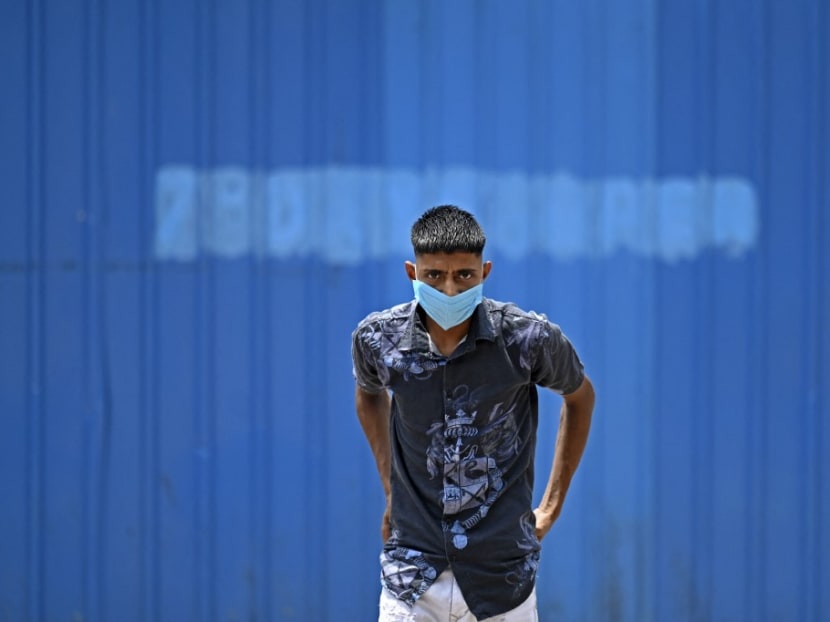 A man wearing a facemask as a preventive measure against the spread of the Covid-19 coronavirus, walks along the roadside in New Delhi on July 5, 2021.