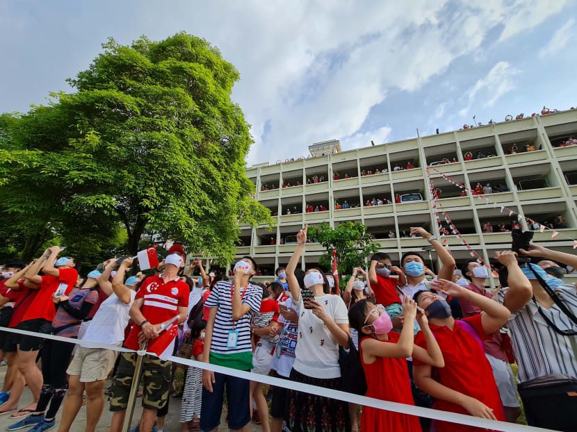 Crowds look on as the Red Lions prepare to land at an open field opposite Blk 285C Toh Guan Road during the National Day Parade on Aug 9, 2020.