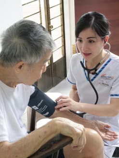 Ms Wee Ai Ling, a hospital-to-home community nurse with Singapore General Hospital, checking a patient's blood pressure during a home visit on May 20, 2024. 