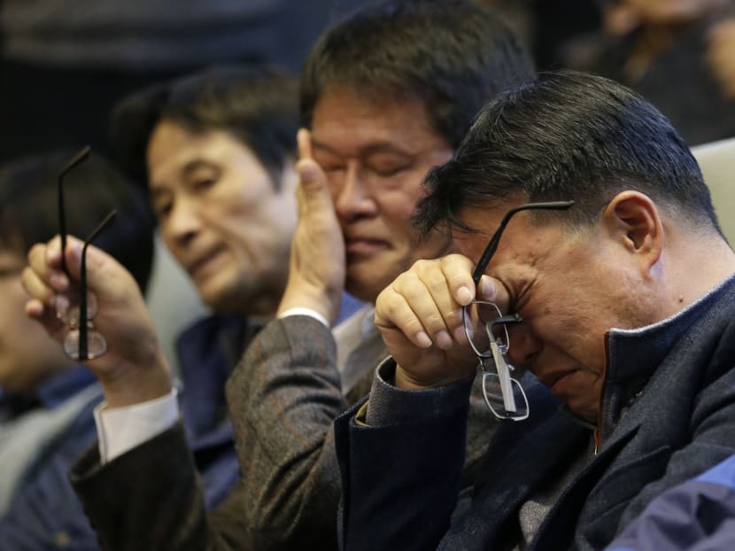 Family members of passengers aboard the sunken ferry Sewol, wipe their tears after South Korean lawmakers voted during the plenary session at the National Assembly in Seoul, South Korea, Friday, Nov 7, 2014. Photo: AP