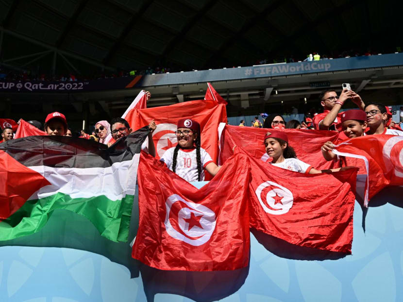 Fans of Tunisia with a Palestinian and Tunisian flags cheer on the stands ahead of the Qatar 2022 World Cup Group D football match between Tunisia and Australia at the Al-Janoub Stadium in Al-Wakrah, south of Doha on Nov 26, 2022.
