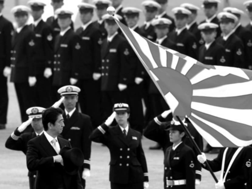 Mr Shinzo Abe (foreground, left) reviewing members of Japan’s Self-Defense Forces last year. He justifies collective self-defence with the term ‘proactive pacifism’, seemingly based on George Orwell’s Big Brother principle that ‘black equals white’. Photo: Reuters
