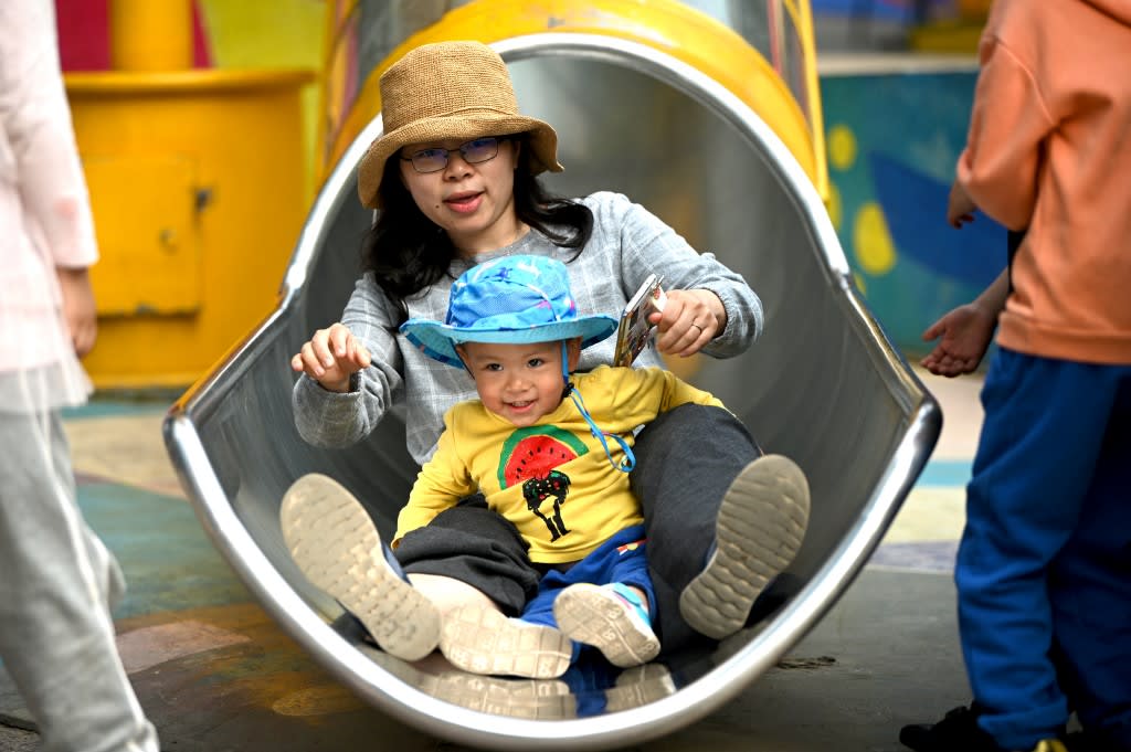 A mother and her baby play on a slide at Wukesong shopping district in Beijing on May 11, 2021.<br />
A mother and her baby play on a slide at Wukesong shopping district in Beijing on May 11, 2021.<br />
