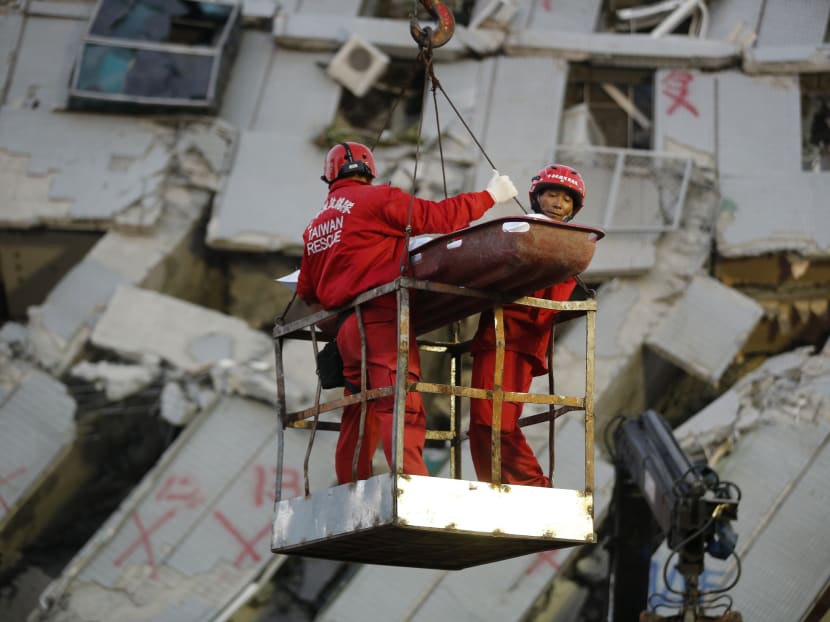 Two emergency workers carry a victim recovered from a collapsed building in Tainan, Taiwan, Sunday, Feb. 7, 2016. Photo: AP