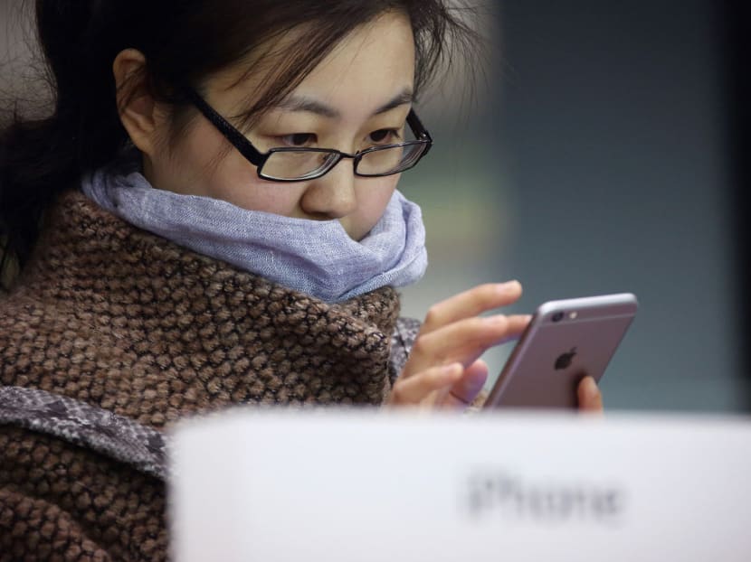 A customer tries an Apple Inc. iPhone 6 at an Apple store in the China Central Mall in Beijing. Photo: Bloomberg