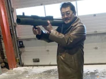 Takeshi Ebisawa poses with a rocket launcher during a meeting with an informant and two undercover Danish police officers at a warehouse in Copenhagen, Denmark February 3, 2021, in a photograph from a Drug Enforcement Administration (DEA) criminal complaint.   U.S. Magistrate Judge/Southern District of New York/Handout via REUTERS/File Photo