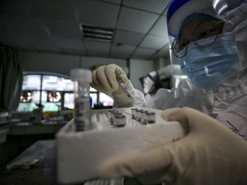 A medical staff member holds samples from patients infected by the Covid-19 coronavirus before a nucleic acid test at the Red Cross Hospital in Wuhan, Hubei province, China, on March 10, 2020.
