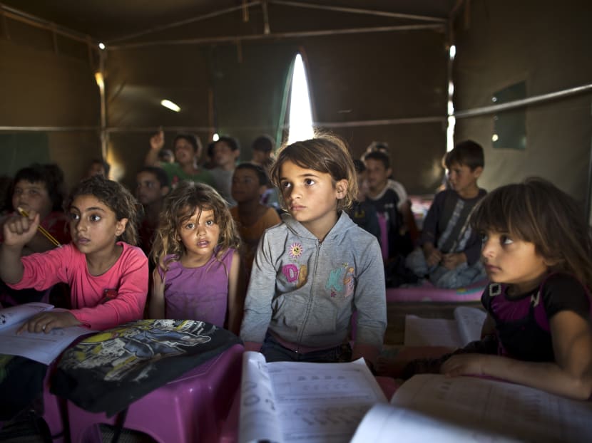 In this Aug 11, 2015 file photo, Syrian refugee children attend a class at a makeshift school set up in a tent at an informal tented settlement near the Syrian border on the outskirts of Mafraq, Jordan. Photo: AP