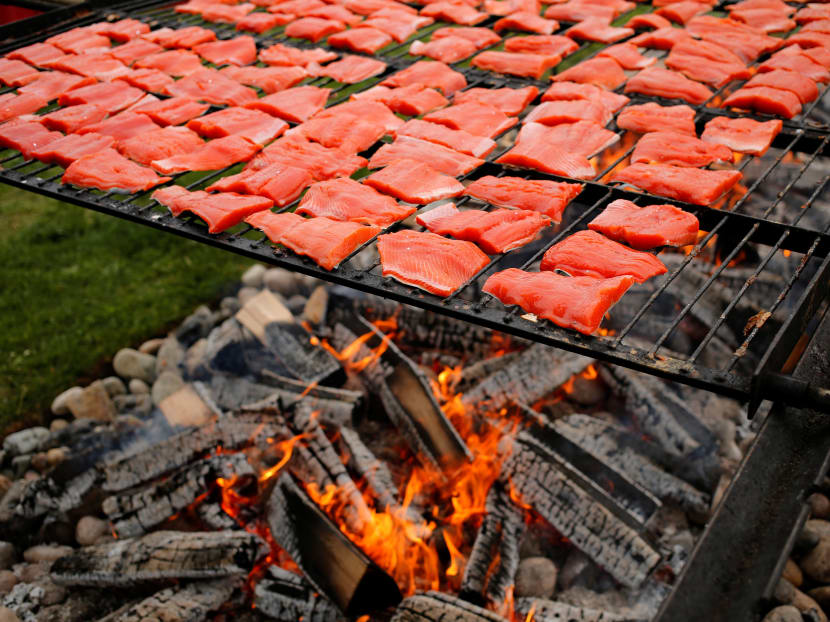3,000 pieces of salmon cooking over an alder wood fire to celebrate Canada Day at the annual Steveston Salmon Festival in Canada on July 1, 2016.  Photo: Reuters