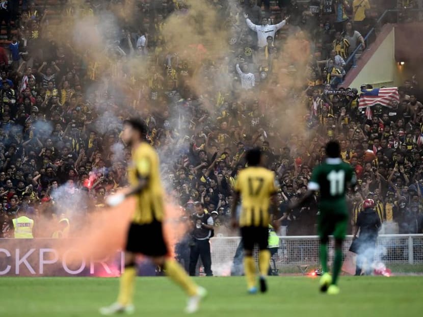 Malaysian football fans throw flares on the pitch in a separate match during the 2018 World Cup qualifying football match between Malaysia and Saudi Arabia on September 8. Photo: AFP