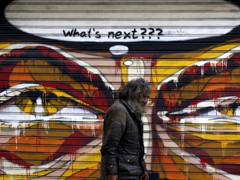A man walks by a mural in Athens, Greece July 14, 2015. Photo: Reuters