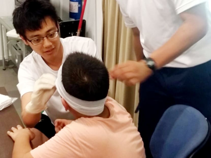 Singapore Red Cross (SRC) volunteer Ivan Low (left), 22, treating a casualty at a temporary first-aid post set up by the SRC at Pulau Ubin. Photo: Red Cross