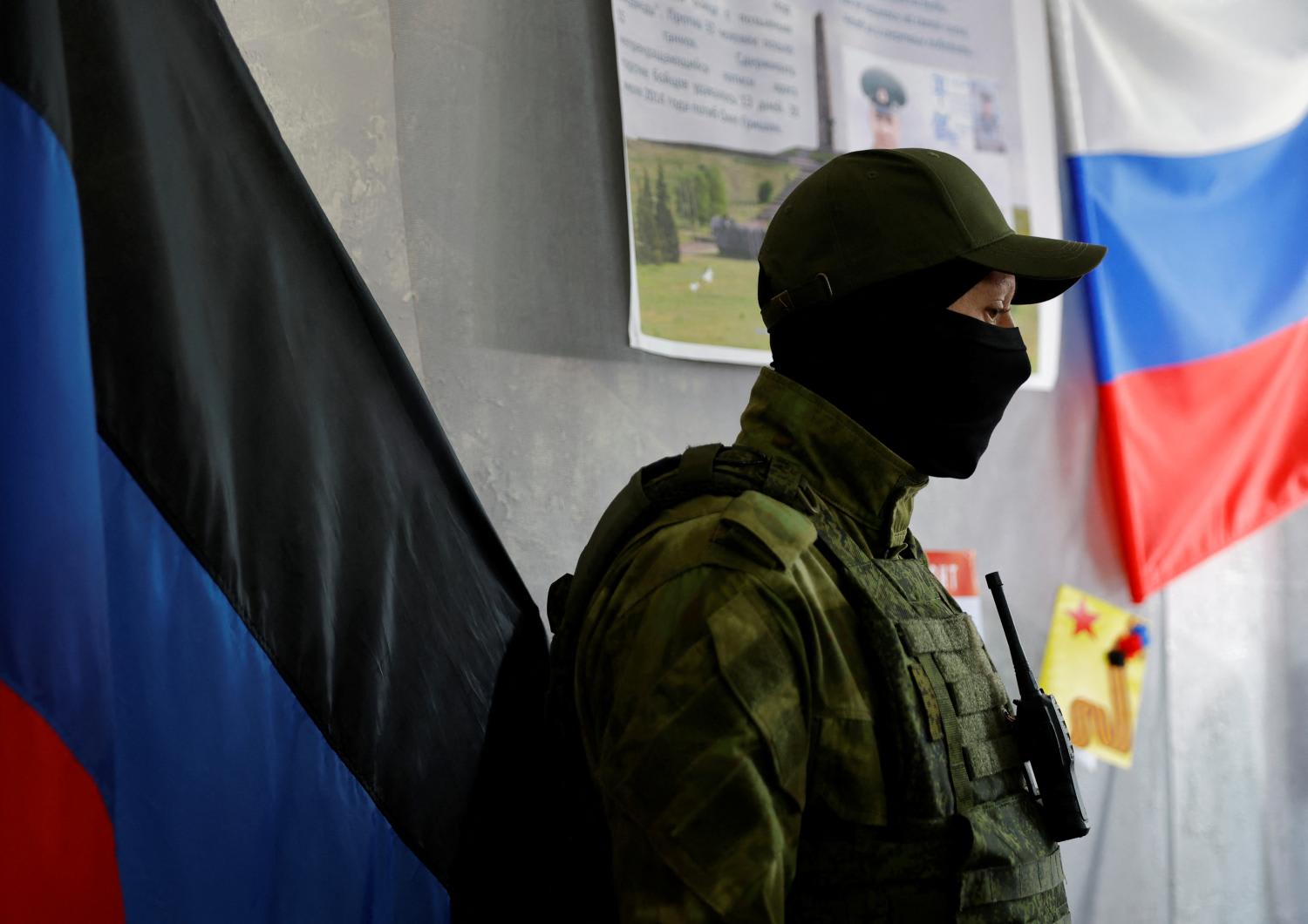 A service member of the self-proclaimed Donetsk People's Republic stands guard at a polling station ahead of the planned referendum on the joining of the Donetsk people's republic to Russia, in Donetsk, Ukraine Sept 22, 2022.