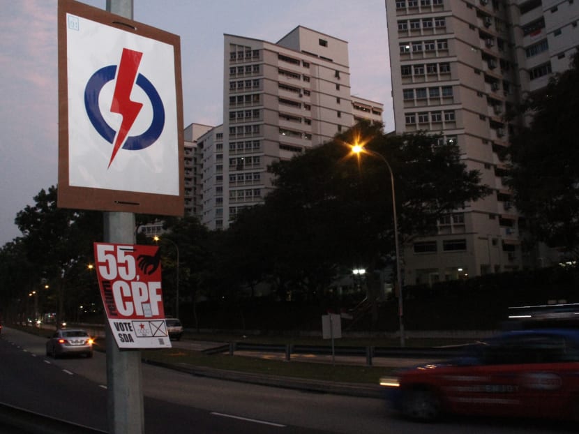 Poster of SDA, in red, seen beneath a PAP's candidate poster at Pasir Ris drive 12. Photo: Daryl Kang