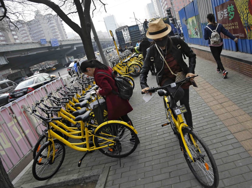 In this Tuesday, March 21, 2017 photo, commuters use bicycles from bike-sharing company Ofo placed on the sidewalk in Beijing, China. Photo: AP