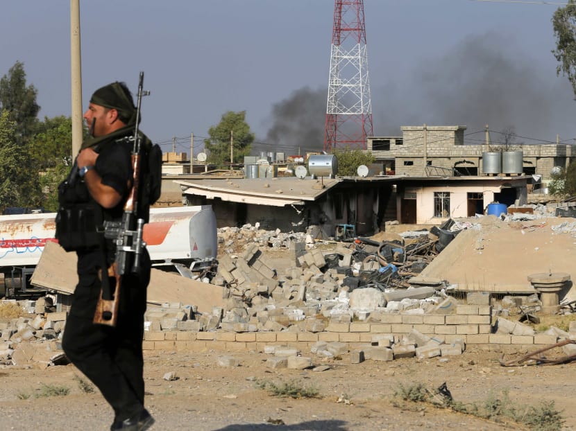 A Kurdish Peshmerga fighter walks past a house destroyed by American air strikes at Barznki village two days ago in Zummar, controlled by Islamic State (IS), near Mosul, Sept 15, 2014. Photo: Reuters