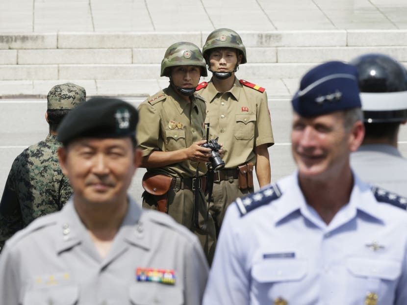 North Korean soldiers (centre in background) looking across the border into South Korea as UN Command soldiers pose for a photo after a ceremony to commemorate the 62nd anniversary of the Korean War, at the border village of Panmunjom in South Korea on Monday. Pyongyang has gone out of its way to thwart hopes that it might be open to a nuclear deal similar to Iran’s. Photo: AP