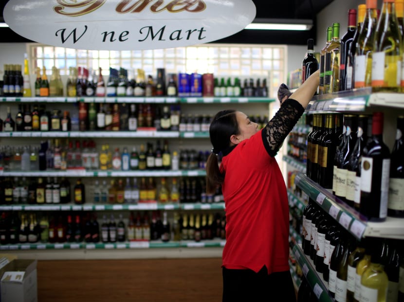 A staff member checks on bottles of wine at a mart, in Shanghai, China, June 2, 2016. REUTERS File Photo