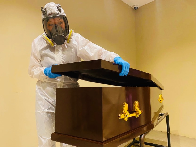 Ms Angjolie Mei preparing a coffin to receive the body of a Covid-19 patient. Ms Angjolie Mei preparing a coffin to receive the body of a Covid-19 patient.