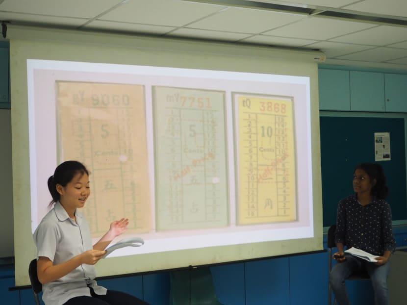 Secondary Two students from Beatty Secondary School, roleplaying a bus driver from the post-independence period (left) and a talk show host (right), show what old bus tickets used to look like. Photo: Louisa Tang/TODAY