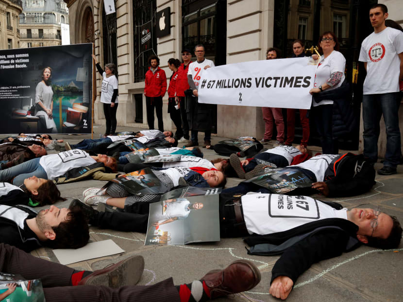 Activists from the anti-globalisation organisation Attac hold a banner reading, "67 million victims", during a protest against alleged tax evasion by Apple in Paris on April 7. The author says while there is backlash against real integration, the absence of even a whiff of protest against financial integration is strange.