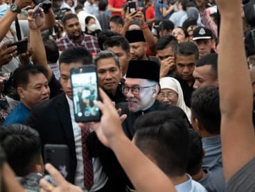 Malaysia's newly appointed Prime Minister Anwar Ibrahim greets his supporters as he leaves his news conference in Sungai Long, Selangor, Malaysia on Nov 24, 2022.
