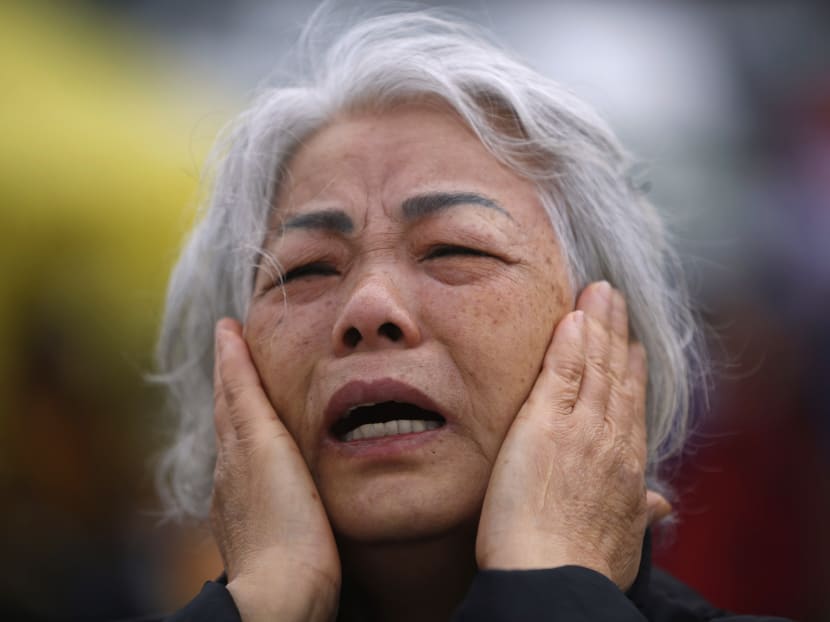 A family member of a missing passenger from the capsized passenger ship Sewol cries as she prays while waiting for news from rescue and salvage teams, at a port in Jindo April 22, 2014. Photo: Reuters