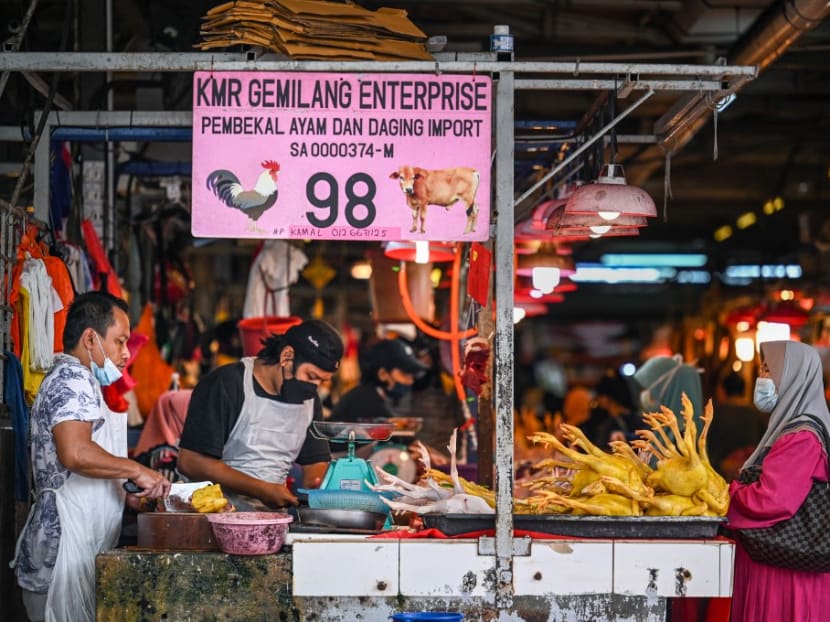 A customer waits to buy chicken meat at a wet market in Kuala Lumpur on Sept 1, 2021.