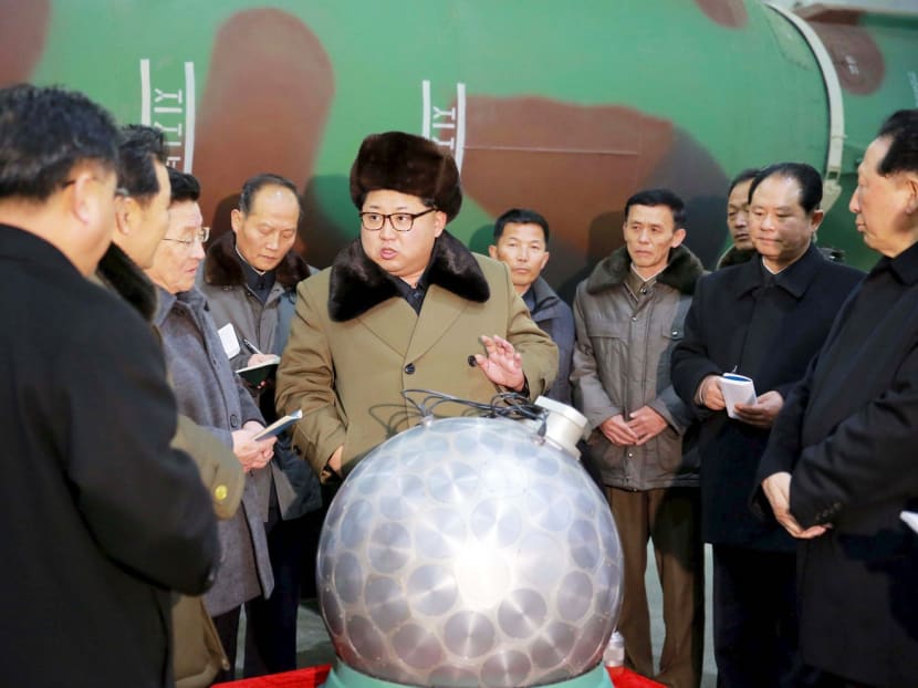 Mr Kim Jong-un with what the CIA calls ‘the disco ball’, a sphere that is supposedly a nuclear weapon, shrunken to fit inside the nose cone of one of the country’s growing arsenal of missiles. Photo: Reuters
