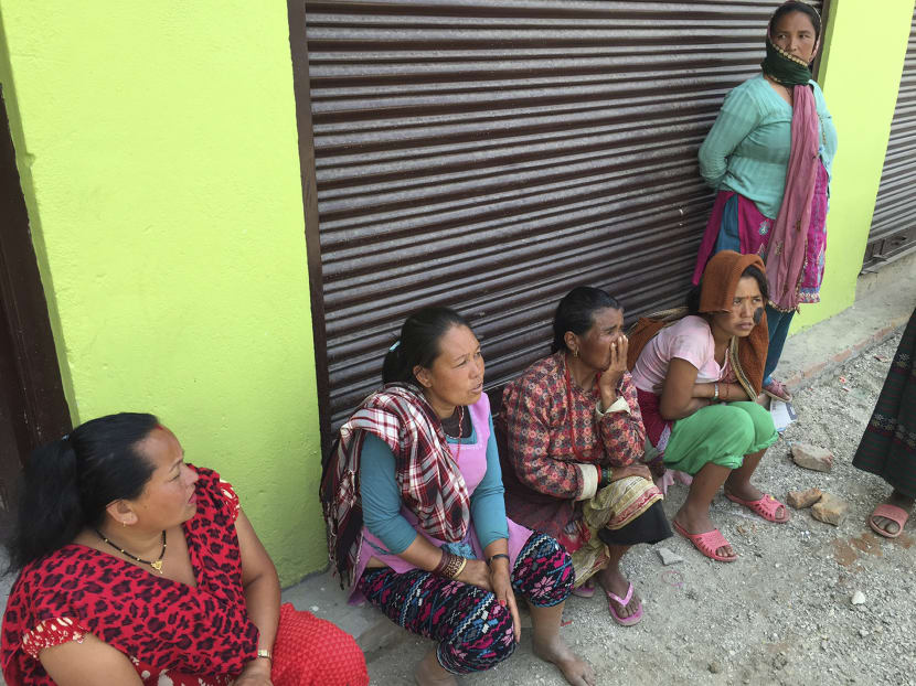 Ms Renu Maya Tsing, second from left, is seated outside of a shop near the town of Sakhu, Nepal. Photo: AP