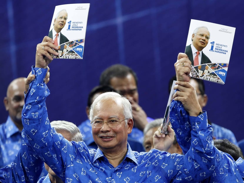 Malaysian Prime Minister Najib Razak, also president of Malaysia's ruling party National Front, holds up a booklet on his party's manifesto for the upcoming general elections during its launch in Kuala Lumpur, Malaysia, Saturday, April 6, 2013. Photo: AP