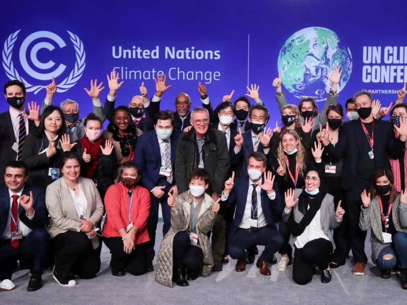Delegates pose for a picture during the UN Climate Change Conference (COP26) in Glasgow, Scotland, Britain on Nov 13, 2021. 