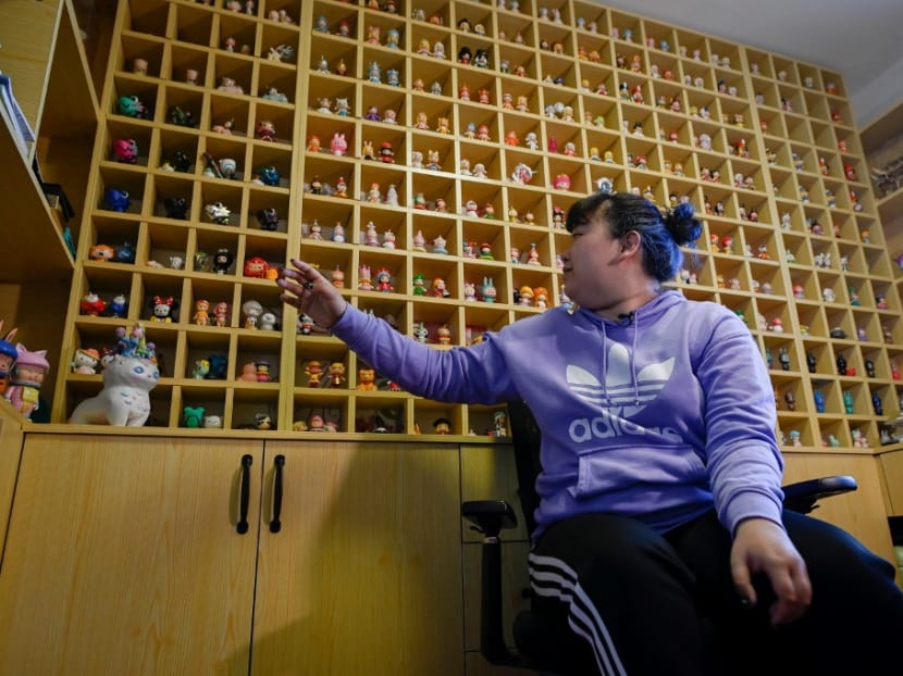 This picture taken on April 13, 2021 shows music student Wang Zhaoxue showing the "blind box" toys she collected, during an interview at her home in Beijing.