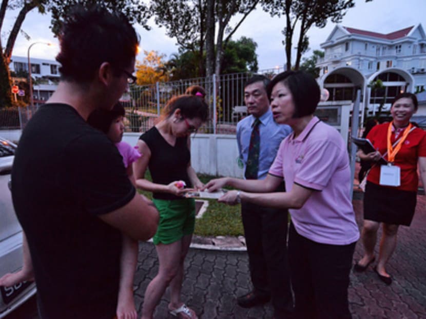 Senior Minister of State Ms Sim Ann (in pink) handing out an information leaflet and a bottle of mosquito repellant to the Chia family, during a walkabout around Watten Estate to raise awareness on the dengue and Zika virus. Photo: Robin Choo/TODAY