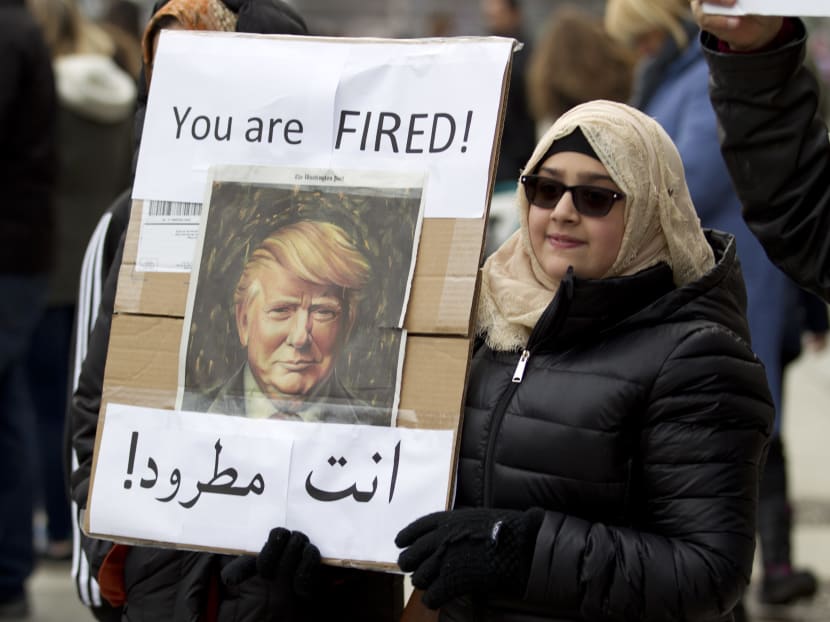 A woman carries a sign outside of the White House during a demonstration to denounce President Donald Trump's executive order that bars citizens of seven predominantly Muslim-majority countries from entering the United States on Jan 29, 2017, in Washington. Photo: AP