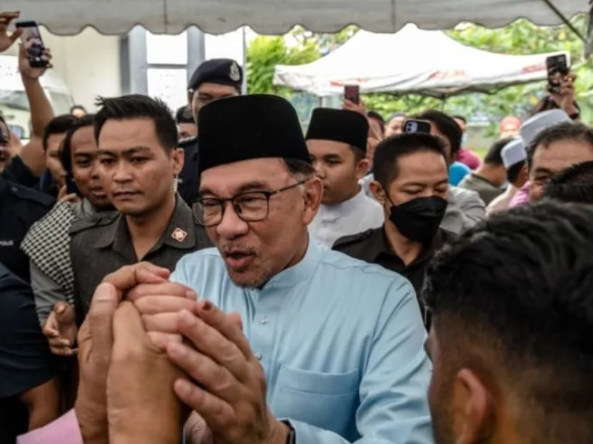 Malaysia's Prime Minister Anwar Ibrahim greets people as he leaves Kampung Baru Jamek Mosque after Friday prayer in Kuala Lumpur on Dec 9, 2022.