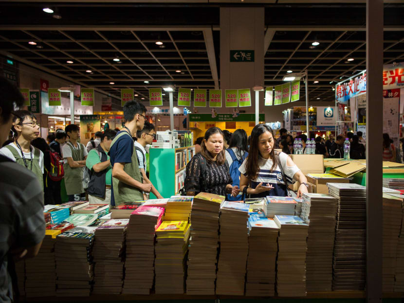 Customers browse books at the annual Hong Kong book fair: The city's feisty publishing industry vowed to take on China by selling books critical of Beijing, despite the disappearances of five city booksellers. Photo: AFP
