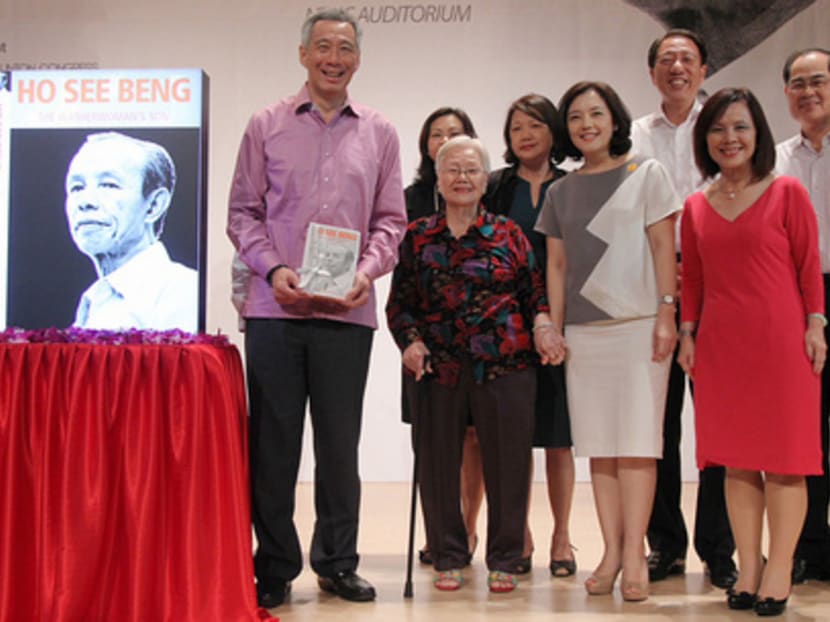 Prime Minister Lee Hsien Loong (left), Deputy Prime Minister Teo Chee Hean (third from right) and Trade and Industry Minister Lim Hng Kiang (right) with Mr Ho’s family members. Don Wong