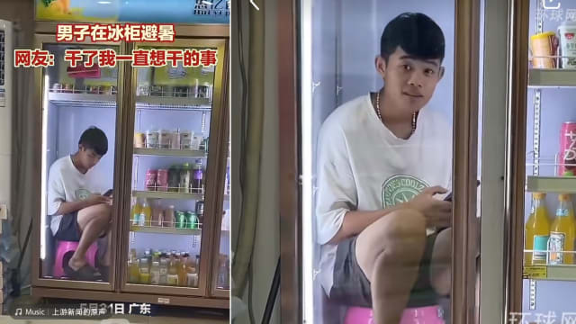 难忍天气太热 广东男子坐冰柜滑手机
