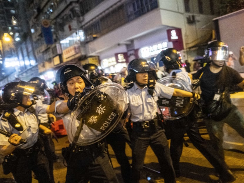 A police officer in riot gear aims a gun at protesters during a clash in the Tsuen Wan district of Hong Kong on Aug 25, 2019.