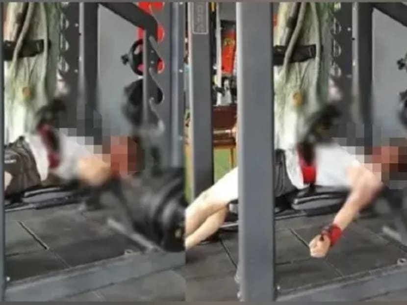 Screengrabs from a video circulating on news platforms of the incident showed Zhang struggling to free himself from under the barbell. Screengrabs from a video circulating on news platforms of the incident showed Zhang struggling to free himself from under the barbell.