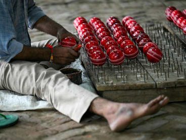 In this photograph taken on Sept 14, 2023, a worker polishes cricket balls at a workshop in Meerut in India's northern state of Uttar Pradesh.
