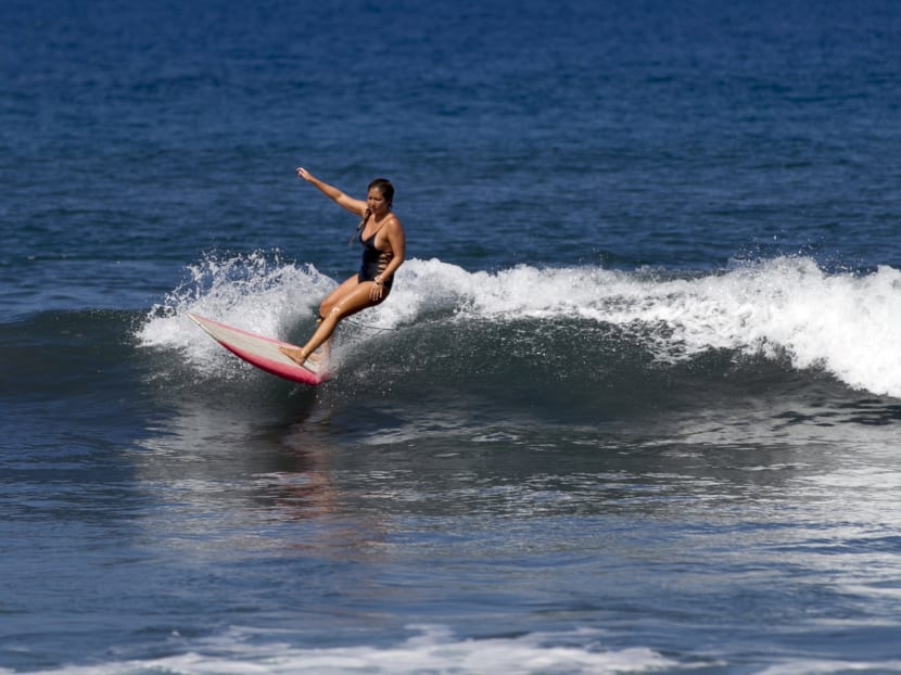 A surfer catches a wave. Photo: Reuters